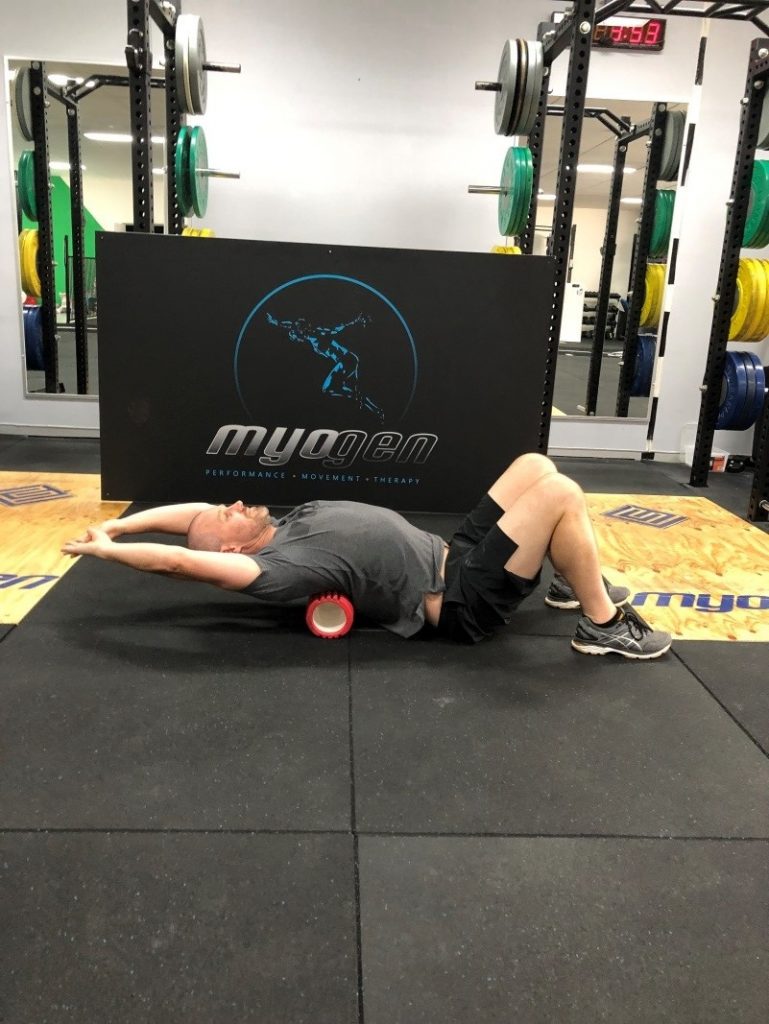 Antony Choice, Director and Soft Tissue Therapist at Myogen, demonstrating a modified foam roller stretch with extended arms.