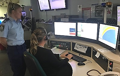 Senior Police Officer Overlooking Officer Working on Specialised Computer Console